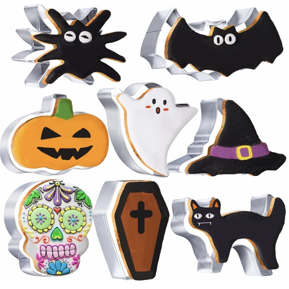 A collection of Halloween-themed cookie cutters featuring various shapes: a spider, a bat, a jack-o'-lantern, a ghost sandwich, a witch's hat, a sugar skull, a coffin, and a black cat. The cookie cutters are decorated in bright, festive colors.